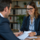 Femme d'affaires en costume bleu discutant avec un client dans un bureau moderne